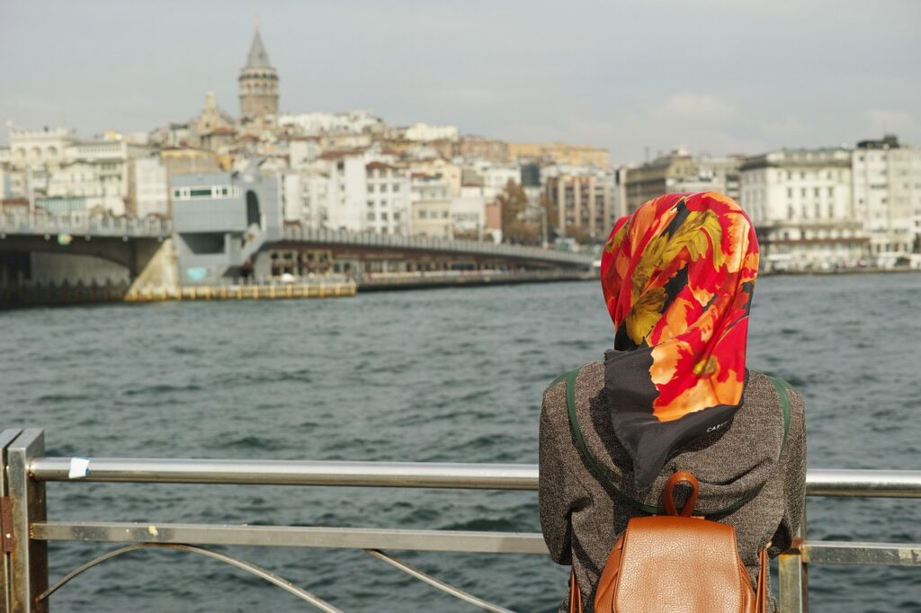 woman in istanbul turkey with head scarf and galata tower in the background